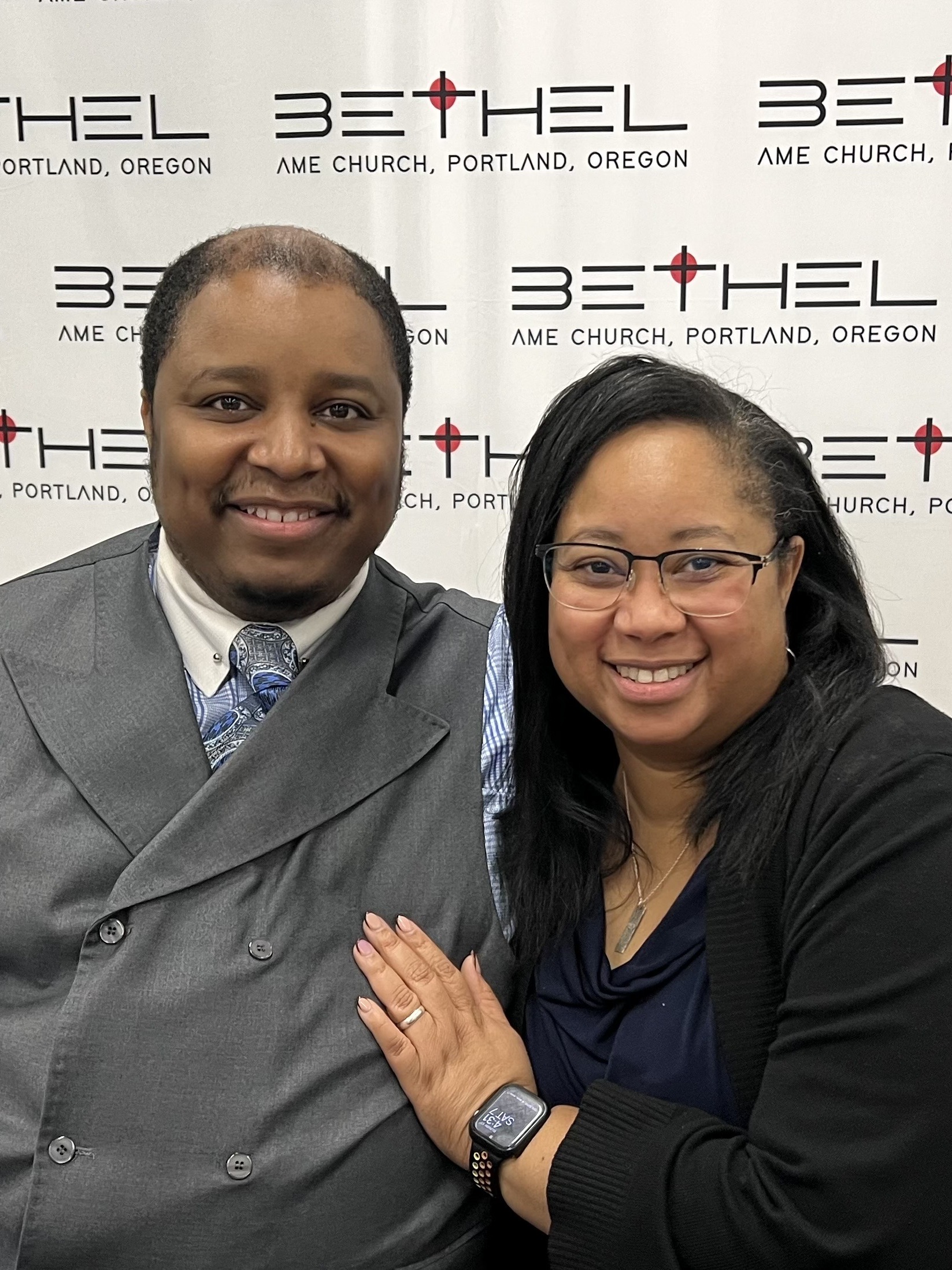 Pastor Phillip E Ross on left First Lady Andrea on the right behind them is a conference backdrop with the Bethel church logo